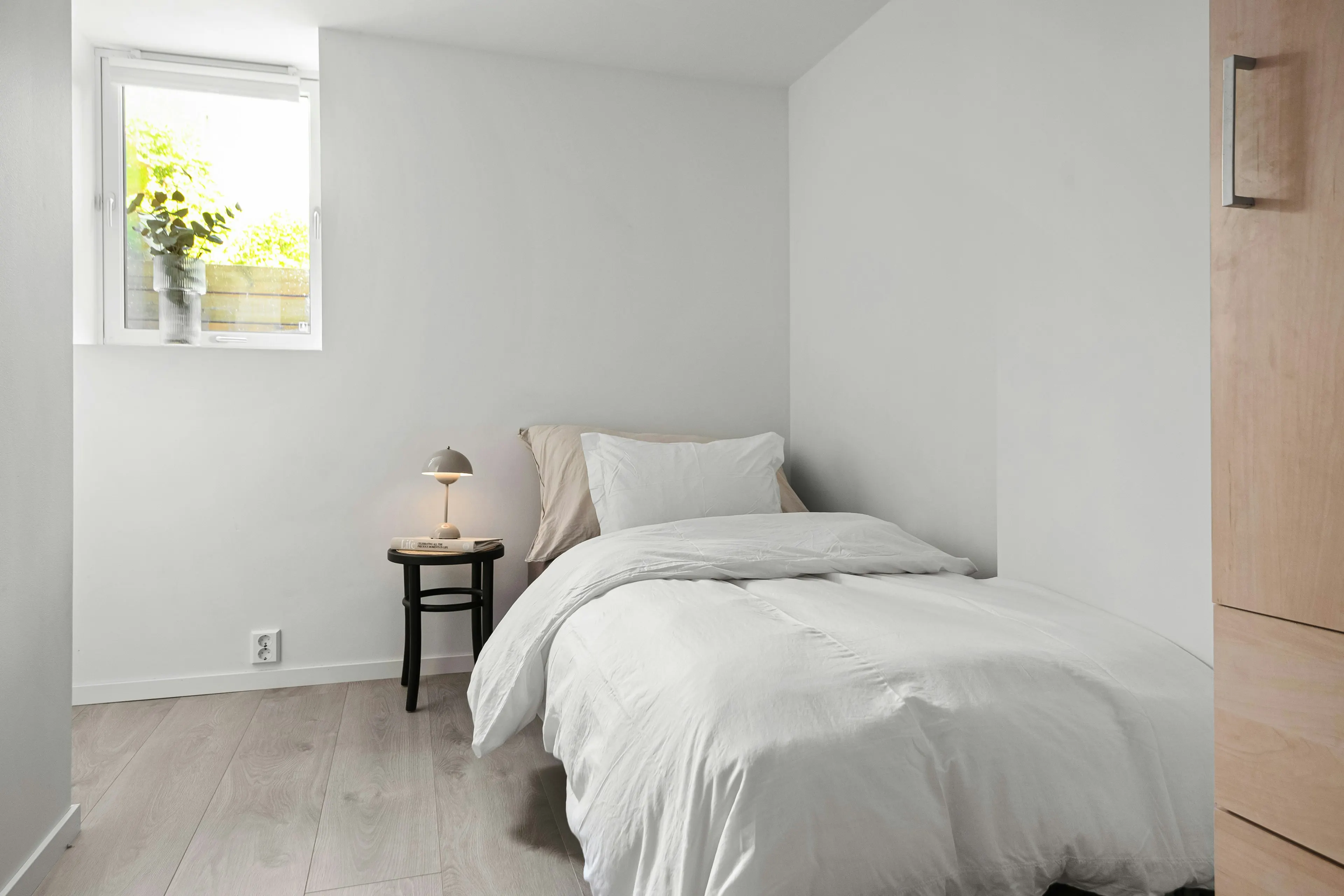 Single bed with white bedding in a bright room (reference image)