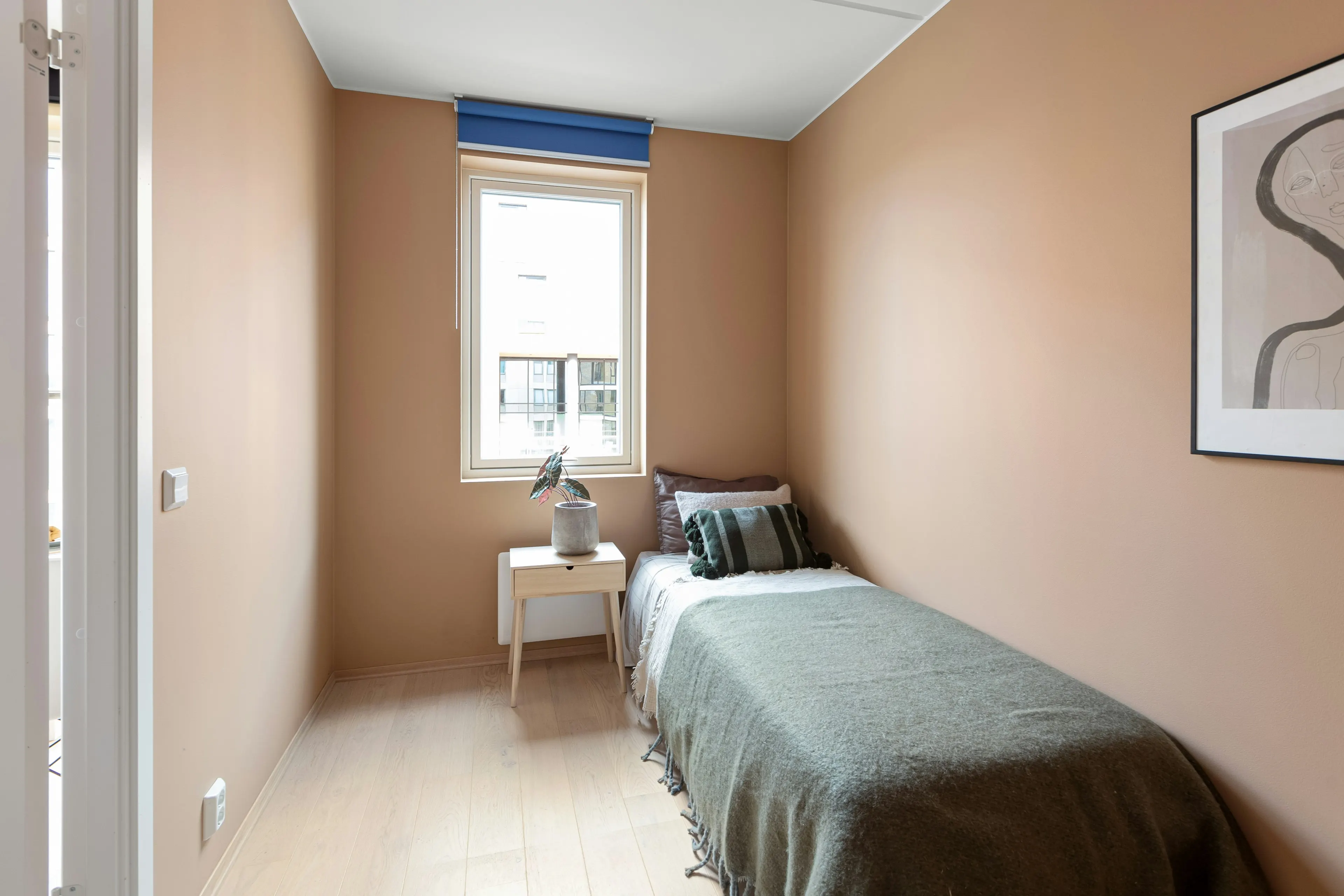 Single bed with a sage green throw (reference image)